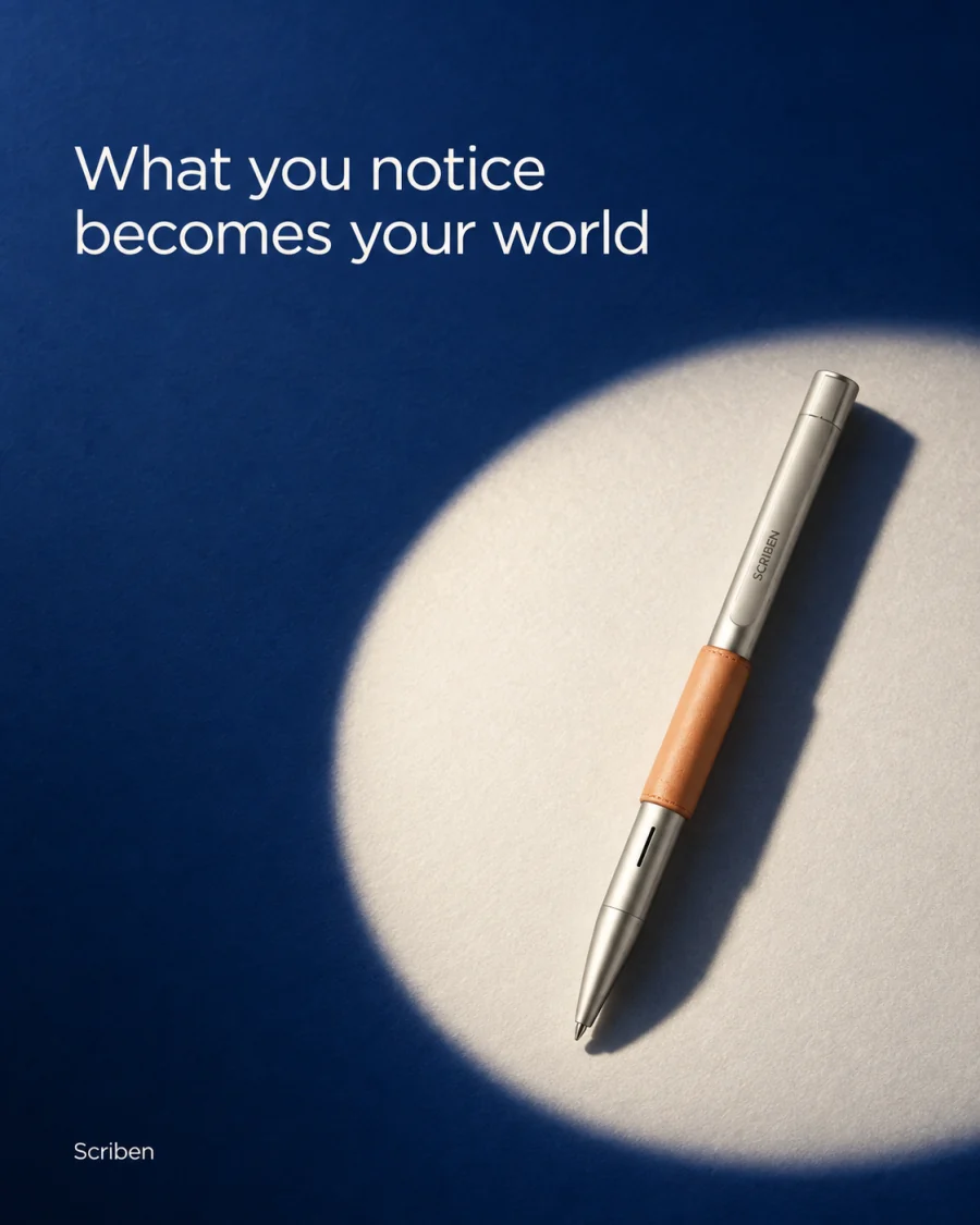 What you notice becomes your world. A pen lit on deep blue.